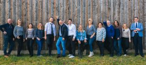 Gruppenbild Vorstand vor einer braunen Holzwand